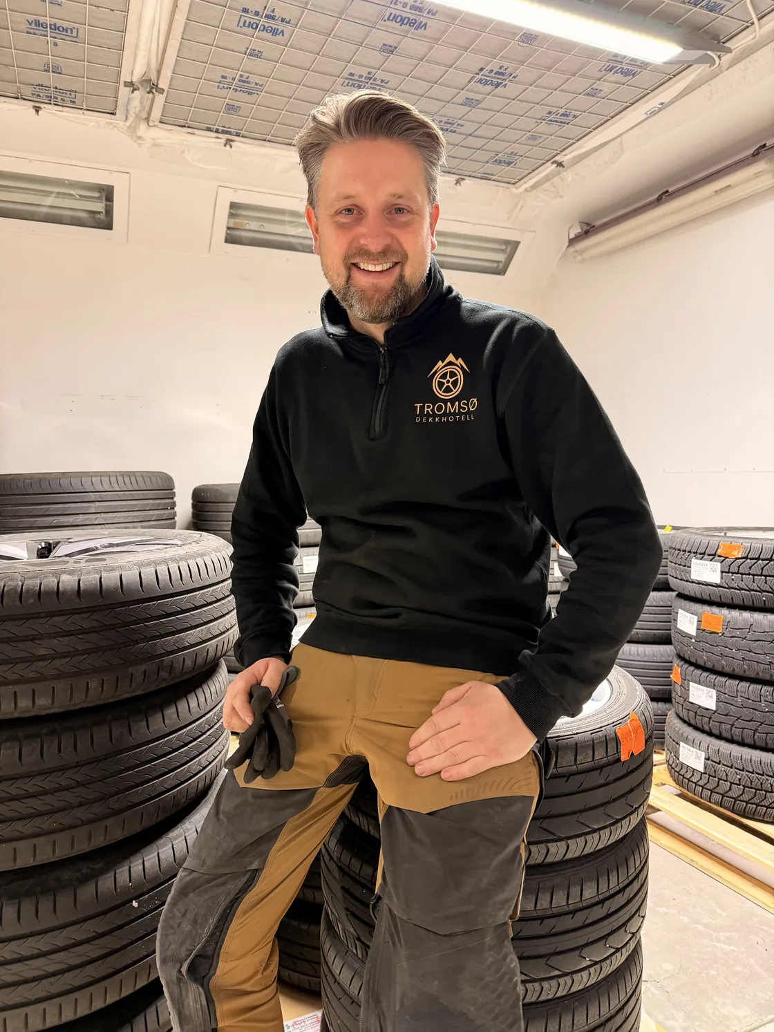 Cato sitter mellom stabler med merkede dekk på dekklageret